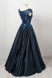 Élégante casquette bleu marine manches longues une longue robe de bal avec des appliques